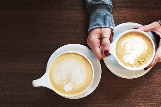 one woman's hands and two coffee cups