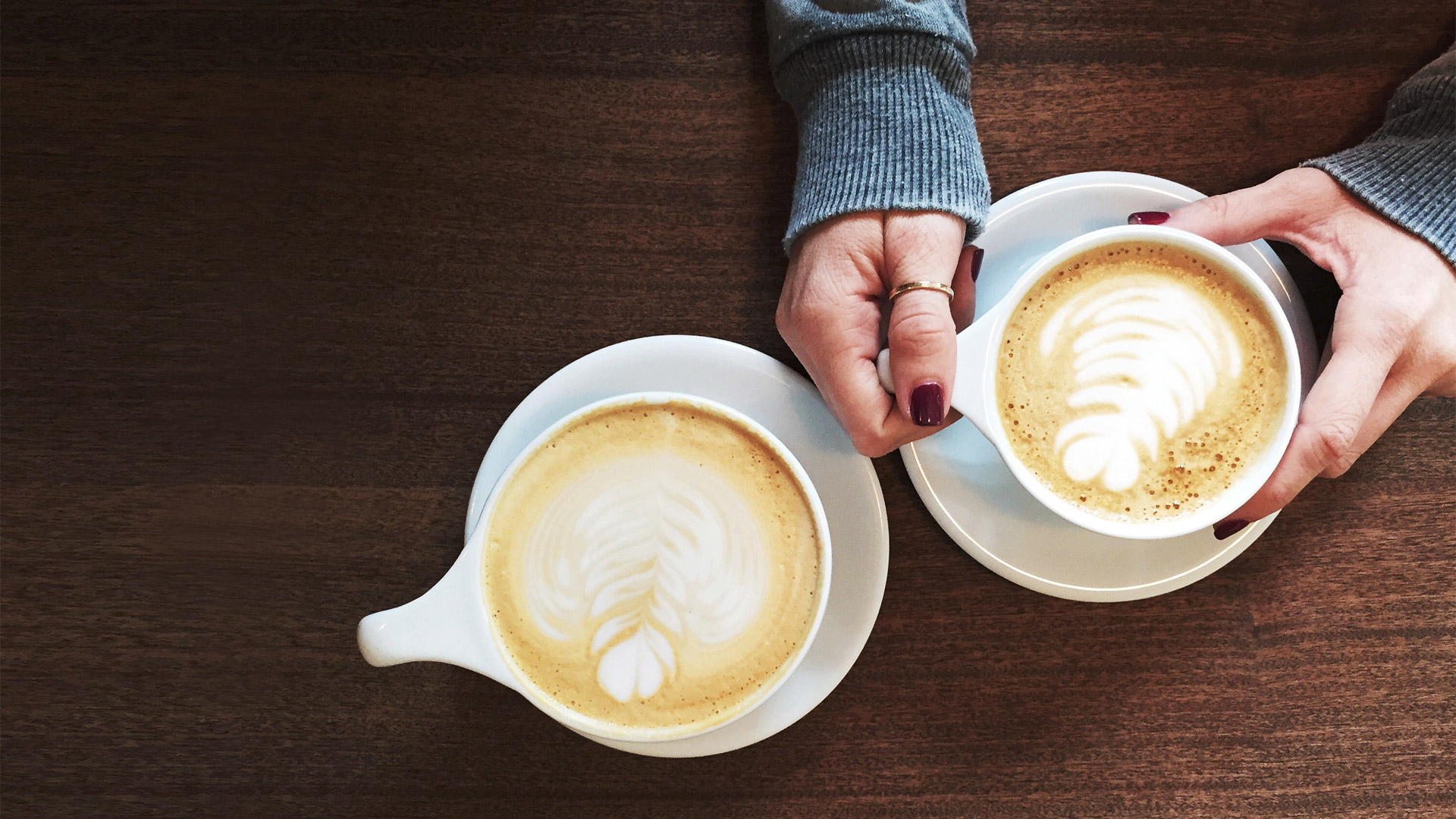 one woman's hands and two coffee cups