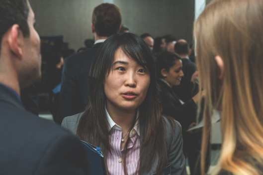 woman soeaking to two people at networking event