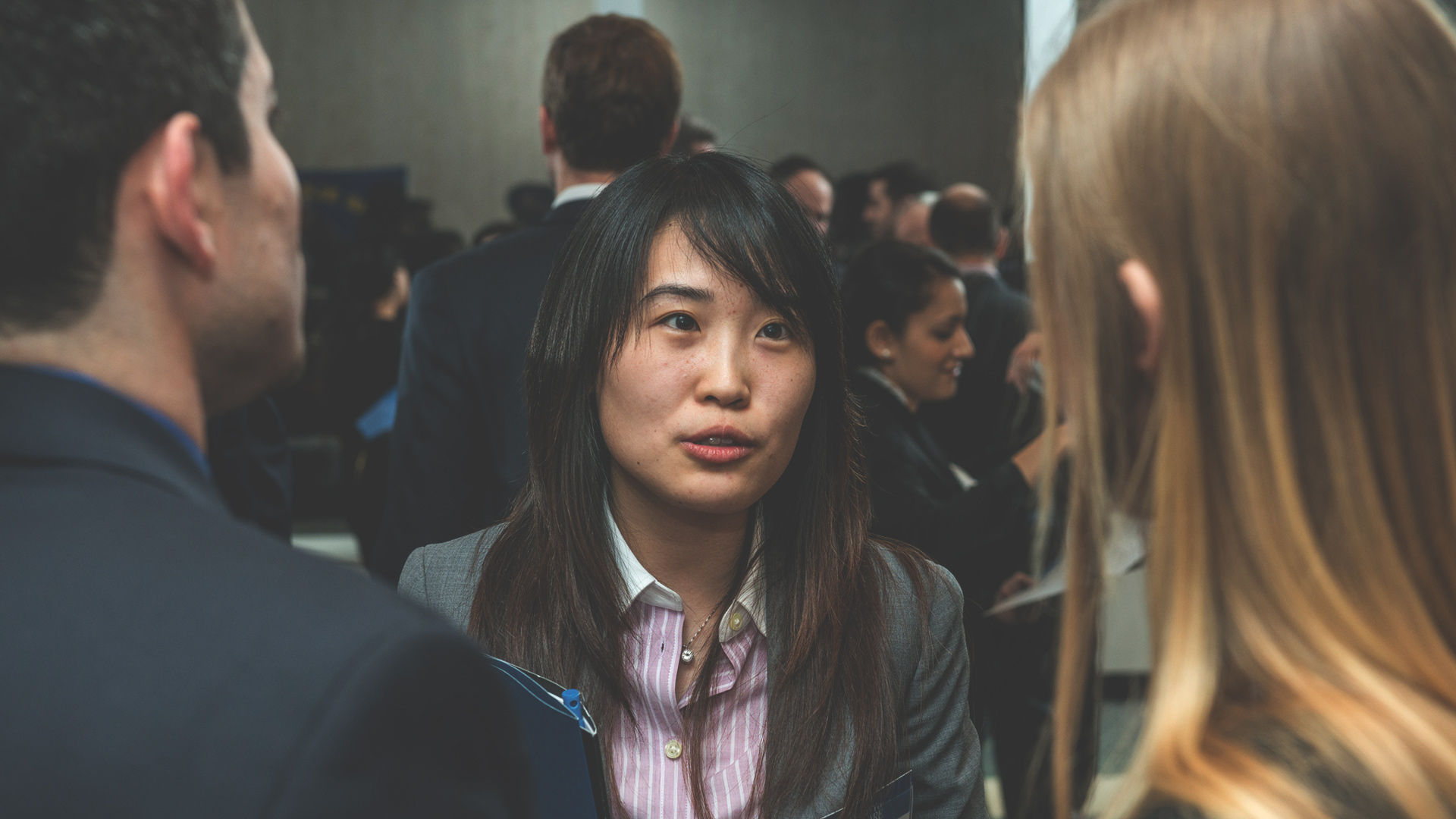 woman soeaking to two people at networking event
