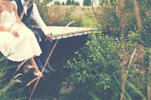 couple sitting on a deck on their wedding day