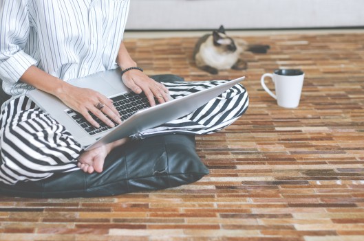Woman working on her laptop on the floor