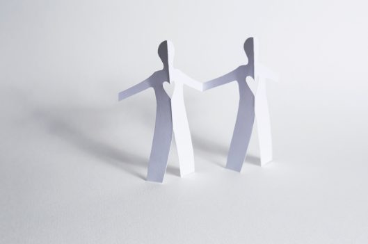Paper cut out figures holding hands