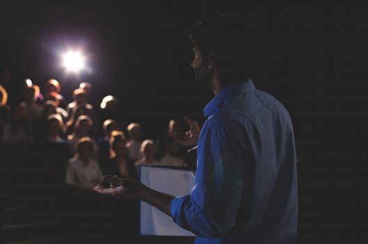 Man giving a speech in front of a crowd