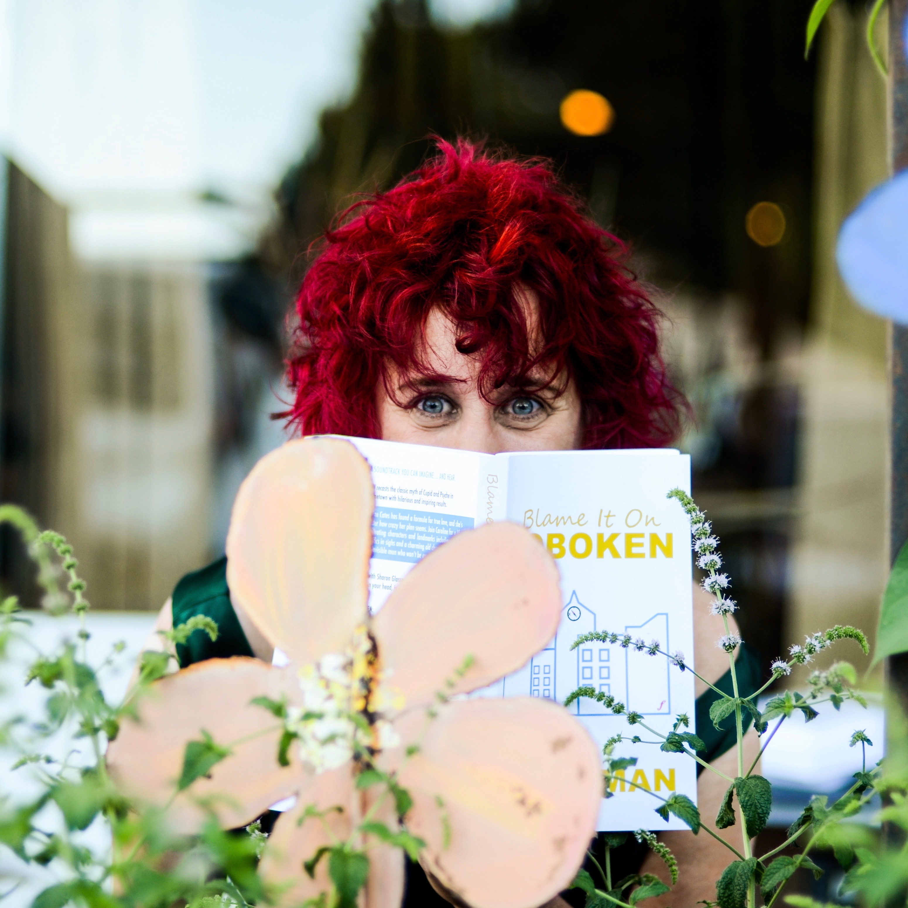 Sharon Glassman author photo with flowers and book
